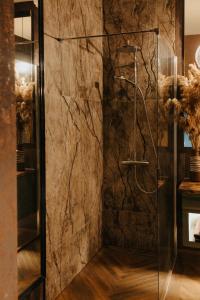 a bathroom with a shower with a stone wall at Apartamenty Zamkowe Centrum in Kwidzyn