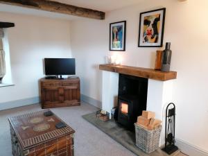 a living room with a fireplace and a tv at Our Holiday House Yorkshire , Bentham - Children and doggy friendly in High Bentham