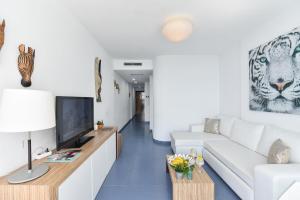 a living room with a white couch and a television at Beach Apartment Playa del Cura 4 in Playa del Cura