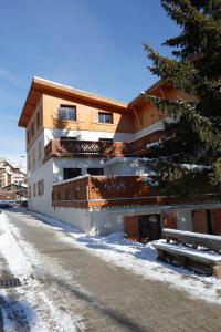 un edificio en una calle nevada con un árbol en Vacancéole - Résidence L'Edelweiss, en Les Deux Alpes