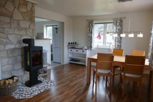 a living room with a fireplace and a table and a stove at Koselig Hytte i Nykvåg in Nykvåg
