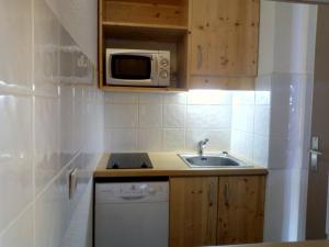 eine kleine Küche mit einer Spüle und einer Mikrowelle in der Unterkunft Appartement Méribel, 1 pièce, 4 personnes - FR-1-355-178 in Méribel