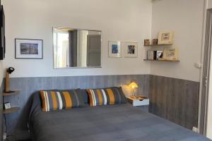 a bedroom with a bed and a mirror on the wall at La Baie Latitude, gîte proche mer avec jardin in Le Crotoy