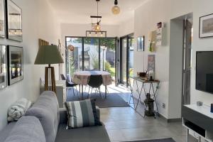 a living room with a couch and a table at La Baie Latitude, gîte proche mer avec jardin in Le Crotoy