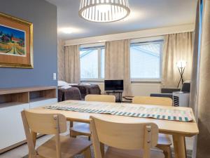 Una cocina y una sala de estar con mesa y sillas. en JK-Apartment Sampola, en Lapua