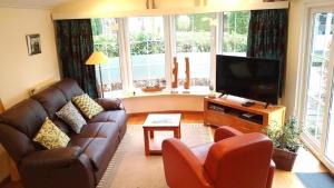 sala de estar con sofá y TV de pantalla plana en Boshuisje en Wageningen