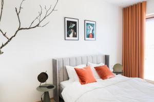 a bedroom with a bed with orange pillows at Kadriorg Plaza 2 bedroom FREE Parking in Tallinn