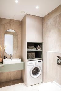 ein Badezimmer mit einer Waschmaschine und einem Waschbecken in der Unterkunft Kadriorg Plaza 2 bedroom FREE Parking in Tallinn