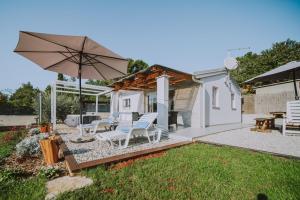 a patio with two chairs and an umbrella at Villa Molo in Novigrad Istria