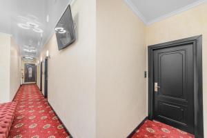einen Flur mit rotem Teppich und schwarzer Tür in der Unterkunft Arcadia Plaza Apartments in Odessa + 17 Fotos