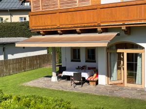 een patio met een tafel in de achtertuin van een huis bij Appartement Erler in Sankt Johann in Tirol