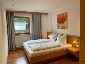 a bedroom with a bed and a window at Appartement Erler in Sankt Johann in Tirol