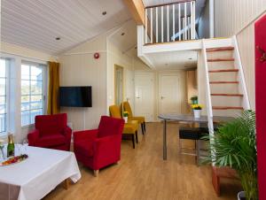 a living room with a table and chairs and a staircase at Arendal Herregaard Spa & Resort in Arendal