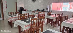 ウバトゥバにあるSuítes Ubatuba Praia da Lagoinhaの部屋にテーブルと椅子があるレストラン