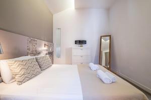 1 dormitorio con 1 cama grande y 2 toallas blancas en Cayres Suites Carmo, en Funchal