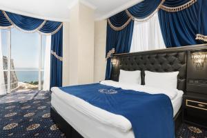 Schlafzimmer mit einem großen Bett und blauen Vorhängen in der Unterkunft Arcadia Plaza Apartments in Odessa