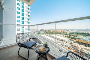 uma varanda com cadeiras e vista para a cidade em HiGuests - Gorgeous Apartment Close to JBR Beach em Dubai