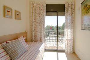 a bedroom with a bed and a balcony at Casa Falset in L'Estartit +28 photos
