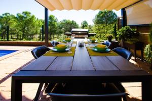 a wooden table on a patio with a piano at Casa Falset in L'Estartit
