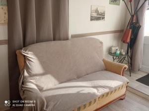 a couch with a blanket on it in a room at L'Eldorado in Courseulles-sur-Mer