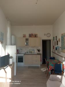 a kitchen with a refrigerator and a table with chairs at L'Eldorado in Courseulles-sur-Mer