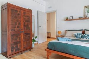 a bedroom with a bed and a large wooden cabinet at G&G Green Garden - Appartamento con Ampio Terrazzo esterno By followgreenhouserome in Rome