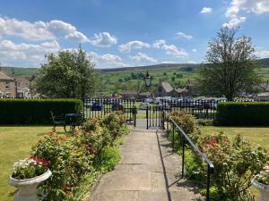 a walkway through a garden with flowers in a park at The Burgoyne in Reeth