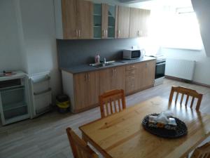 a kitchen with a wooden table and chairs and a kitchen with a microwave at Apartmány Litvínov centrum in Litvínov