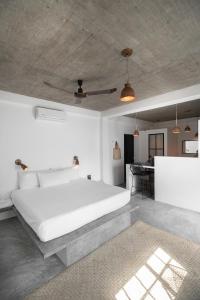 a bedroom with a large white bed and a table at Soiree in Zipolite
