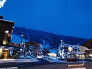 Una ciudad con luces de Navidad en la nieve por la noche en Onnion, en Onnion