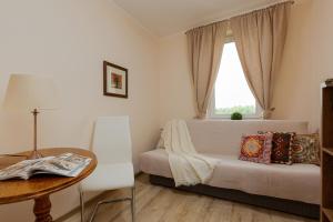 a bedroom with a bed and a table and a window at Royal Park Apartments Warsaw Sielecka by Renters in Warsaw