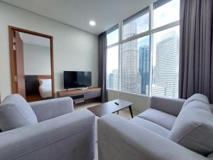 a living room with two couches and a large window at Sky Suites with KLCC Twin Tower View by iRent365 in Kuala Lumpur