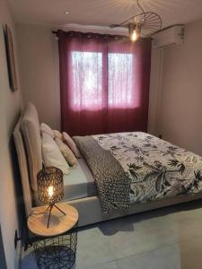 um quarto com uma cama e uma mesa com um candeeiro em Royal Ananas em Saint-Paul