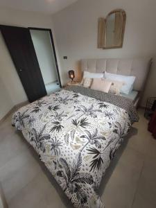 ein Schlafzimmer mit einem großen Bett mit einer schwarzen und weißen Decke in der Unterkunft Royal Ananas in Saint-Paul