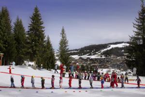 un grupo de personas de pie alrededor de una línea roja en la nieve en Belambra Clubs Les Saisies - Les Embrunes - Ski pass included, en Villard-sur-Doron