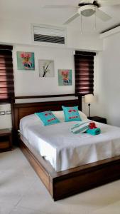 a bedroom with a large white bed with blue pillows at ALIGIO luxury apart-hotel in Las Terrenas