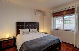 a bedroom with a large bed and a window at Enchanted Villa in Tavira