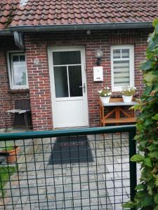 a brick house with a white door and a table at Am Kleinheider Weg in Großheide