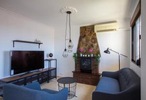 een woonkamer met twee blauwe stoelen en een flatscreen-tv bij Beautiful renovated apartment in Benalmádena