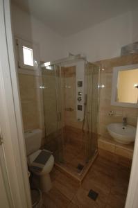 een badkamer met een douche, een toilet en een wastafel bij Pension Ocean View in Naxos Chora