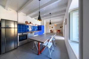 eine Küche mit einem Holztisch und blauen Schränken in der Unterkunft Aphrodite Villas Halki - Villa Bougainvillea in Chalki