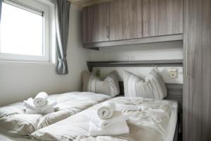 2 Betten mit Handtüchern in einem Schlafzimmer in der Unterkunft Chalet bis 4 Personen ohne Hund - a61158 in Norden