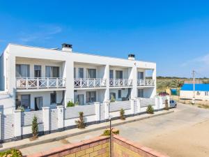 a white apartment building with a white fence at Villa Aquamarin Buhaz in Zatoka