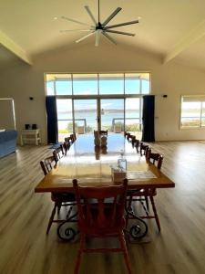 Emu Bay的住宿－Emu Bay Lodge，大型用餐室配有桌椅和大窗户