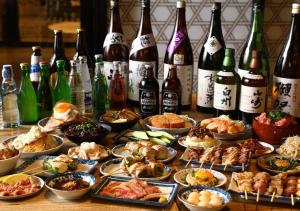 東京にある アパホテル〈上野駅前〉の食べ物とワインのボトルが詰まったテーブル
