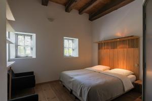 a bedroom with a large bed and two windows at erfgoed Rikkerda in Lutjegast