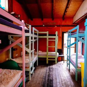 a room with three bunk beds in a house at Nomad Hostel in Nimrod