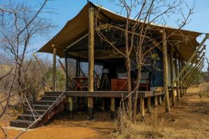 a hut in the middle of a field at Honeyguide Tented Safari Camps - Mantobeni in Manyeleti Game Reserve