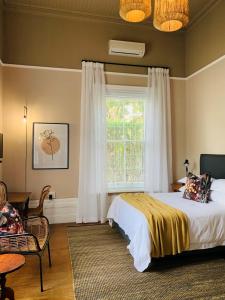 a bedroom with a bed and a window at de Wingerd B & B in Graaff-Reinet