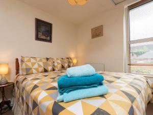 a bedroom with a bed with blue towels on it at The Georgian Cottage in Bedale